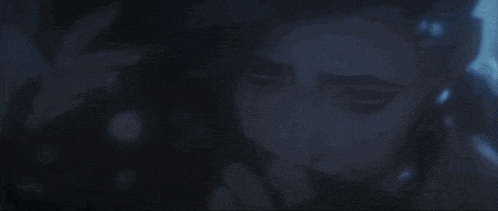a close up of a person 's face in the dark with a blue light coming out of it .