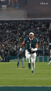a football player wearing a number 1 jersey is running on a field .