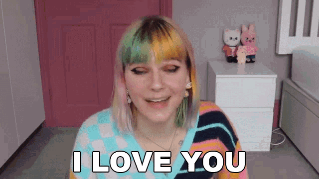 a girl with two different colored hair is smiling and saying i love you .