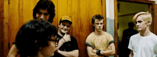 a group of young men are standing next to each other in front of a wooden door .