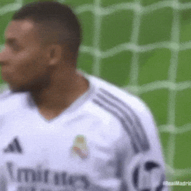 a blurred image of a soccer player wearing a jersey that says emirates