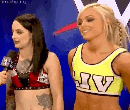 two women are standing next to each other and one of them is wearing a yellow tank top with the word liv on it .