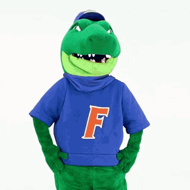 a crocodile mascot wearing a blue shirt with the letter f on it