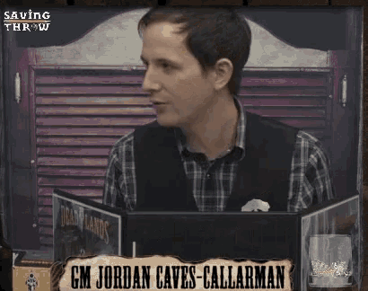 a man in a plaid shirt is sitting at a table with a sign that says gm jordan caves-callarman