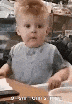 a baby is sitting in a high chair at a table and making a face .