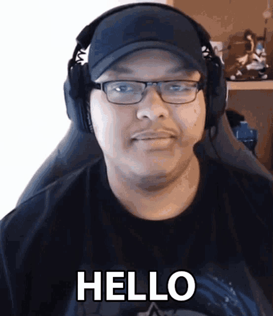 a man wearing glasses and headphones is sitting in a chair and says hello .