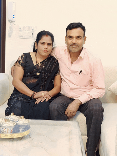 a man and woman are posing for a picture on a couch