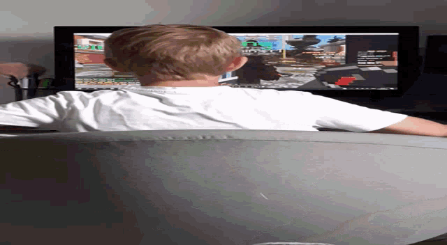 a young boy is playing a video game on a computer monitor