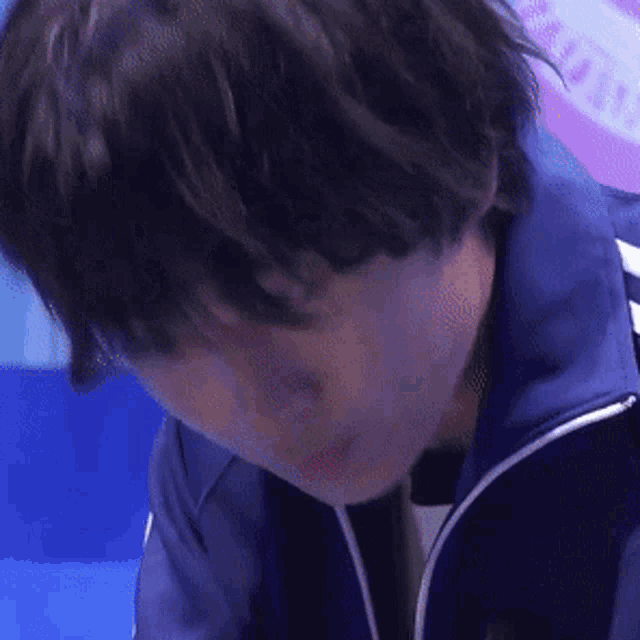 a close up of a person 's face in a blue jacket