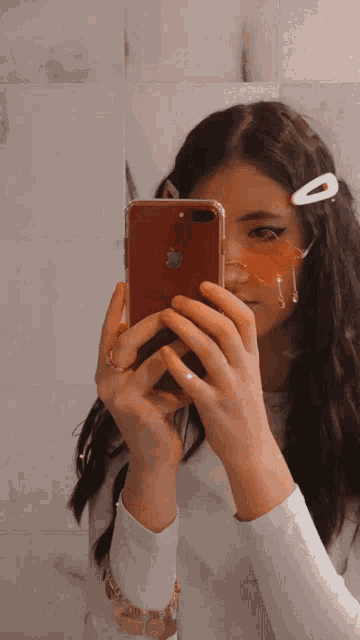 a girl is taking a picture of herself with an apple iphone