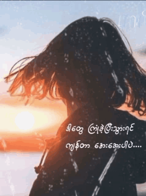 a woman stands in front of a sunset with a quote in a foreign language