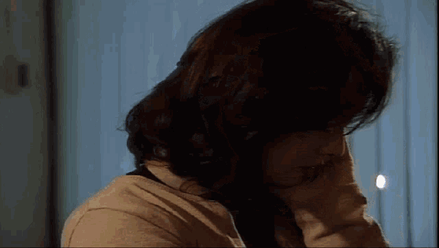 a close up of a woman 's face with a hand on her face