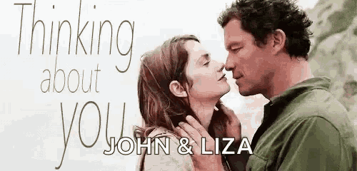 a man and a woman are kissing in front of a sign that says thinking about you .