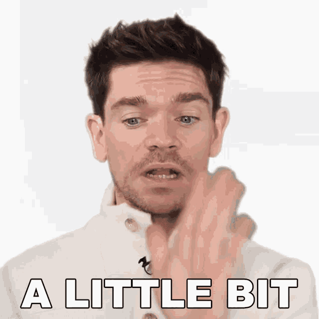 a man in a white jacket says a little bit with his finger