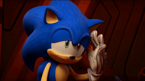 a close up of sonic the hedgehog holding a red object