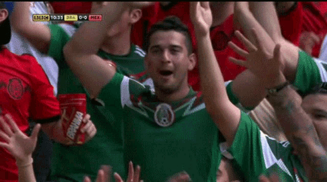 a man in a green jersey holds a can of dr. pepper