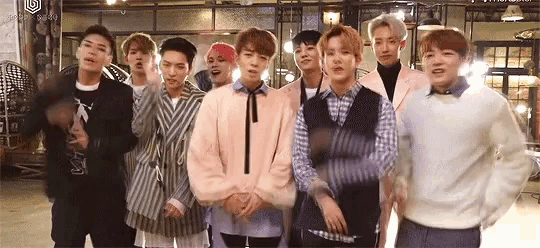 a group of young men are standing next to each other in a room and looking at the camera .