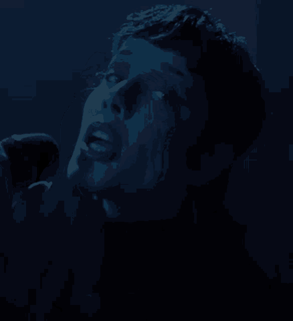 a woman singing into a microphone with her mouth open