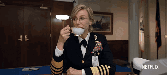 a woman in a military uniform drinking from a cup