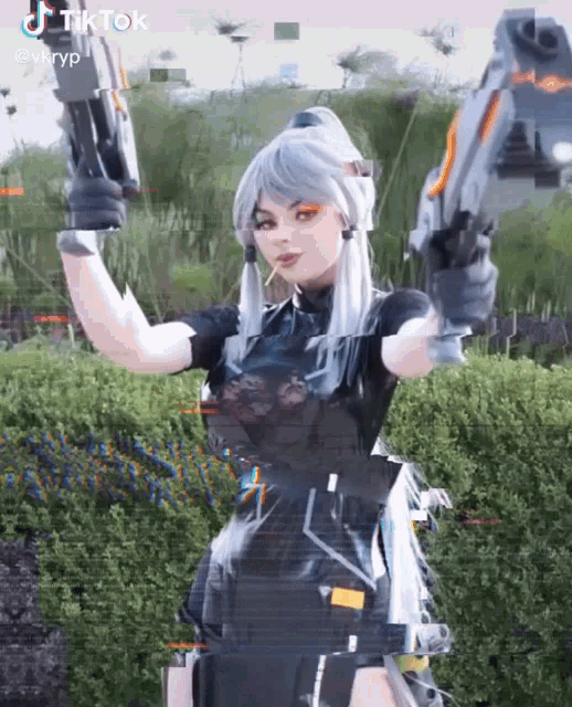 a woman in a black costume is holding two guns in her hands .