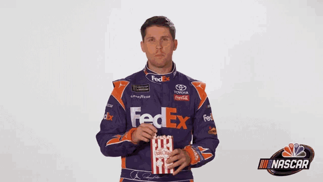 a man in a fedex jacket is holding popcorn