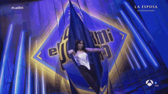 a woman is hanging upside down in front of a sign that says la esposa a continuacion