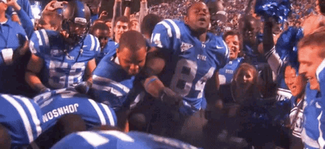 a football player wearing a number 84 jersey is surrounded by other players