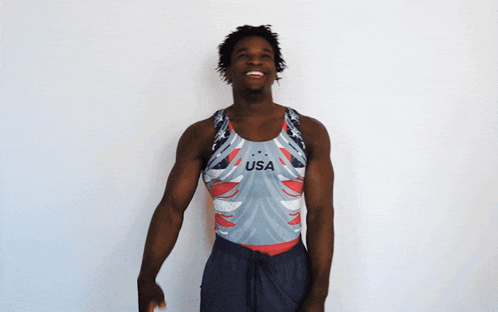 a man wearing a usa tank top is smiling