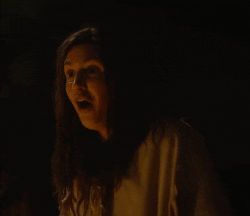a woman is making a funny face in the dark .