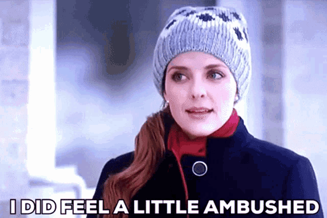 a woman wearing a knitted hat and a coat is saying i did feel a little ambushed .