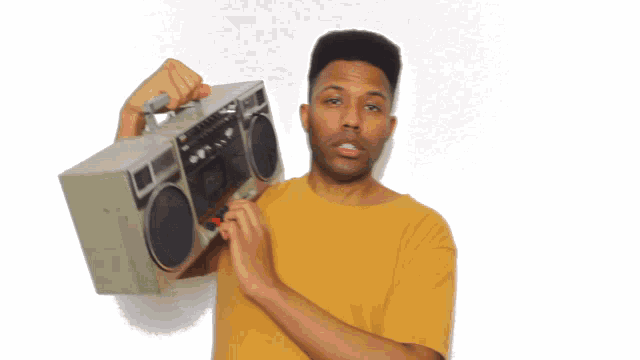a man in a yellow shirt is holding a boombox with a handle