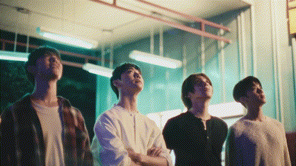 a group of young men are standing next to each other in a room and looking up at the sky .