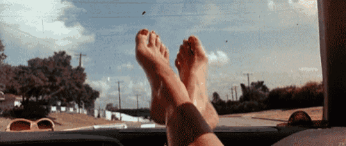 a person 's feet are hanging out of the window of a car .