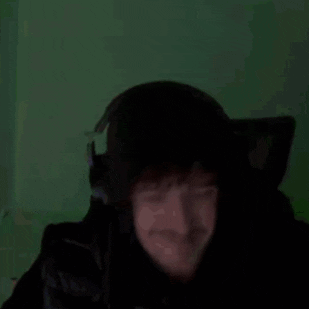 a man is wearing headphones and making a funny face .