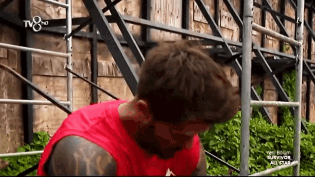 a man in a red tank top is on a tv8 channel
