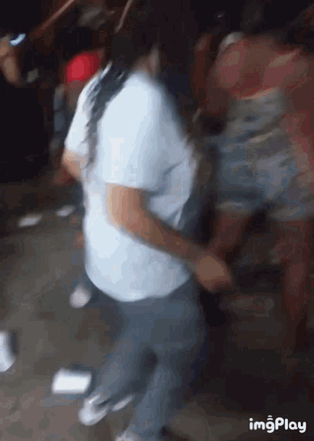 a group of people are dancing in a dark room with the words imgplay at the bottom .