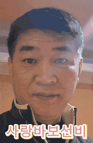 a close up of a man 's face with korean writing on the bottom