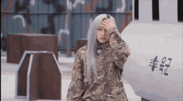 a woman in a military uniform is standing in front of a military vehicle