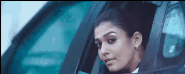a woman is looking out of a car window .