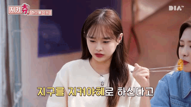 a girl is eating something with a fork and the word dia is on the bottom left