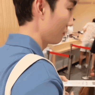 a man in a blue shirt is standing in a line