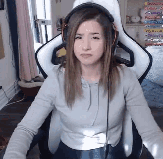 a woman wearing headphones sits in a chair with a screen behind her that says ' conejo ' on it