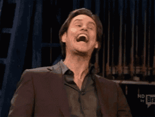 a man in a suit is making a funny face with his mouth open .