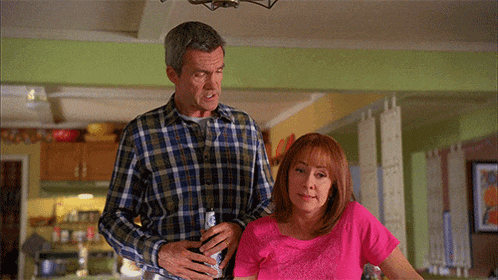 a man and woman standing next to each other in a kitchen