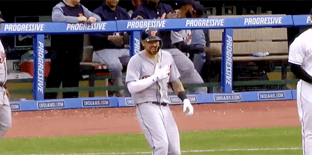 a baseball player stands in front of a progressive fence