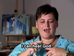 a woman says " i can hear god " in front of an easel
