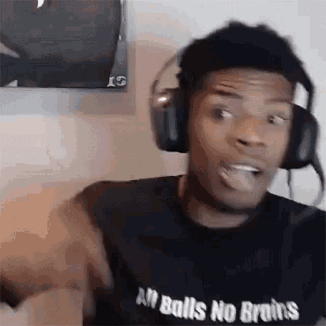 a man wearing headphones and a t-shirt that says `` all balls no brains '' .