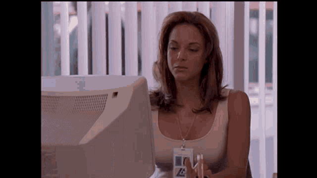 a woman sitting in front of a computer wearing a name tag that says a on it