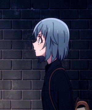 a girl with blue hair is standing in front of a dark brick wall