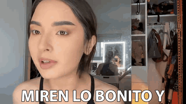 a woman is standing in front of a mirror with the words miren lo bonito y on the bottom